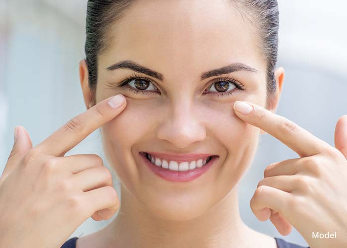 Woman smiling with her hands by her eyes