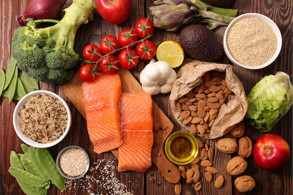 Platter of healthy food including nuts, salmon, and vegetables.