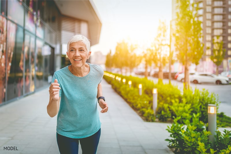 Older woman running on the street to stay healthy. 